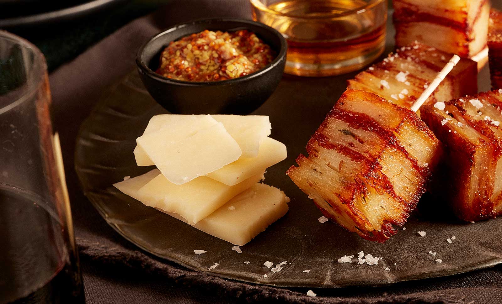 Stacked slices of artisan cheddar cheese with honey served with potato pave.