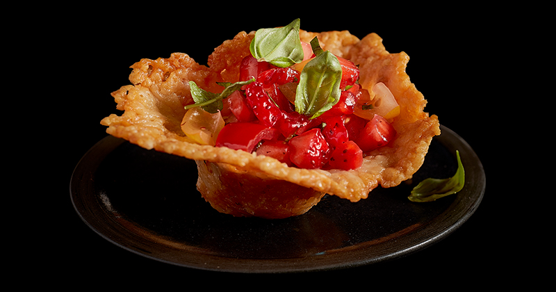 Plan rapproché de coupes de fromage cheddar avec salsa poivrée à la fraise.
